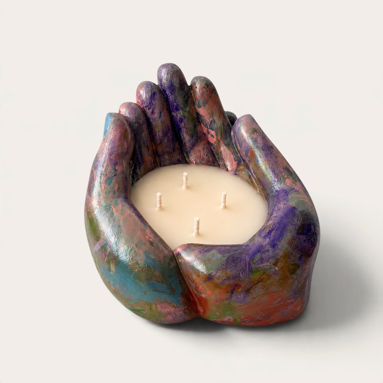Vela artesanal THE IBIZA CANDLES con forma de manos ahuecadas, pintada a mano en tonos azules y multicolores.