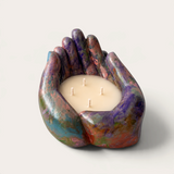 Vela artesanal THE IBIZA CANDLES con forma de manos ahuecadas, pintada a mano en tonos azules y multicolores.